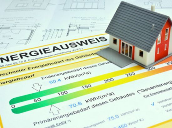 Energieausweis mit Angabe des Energiebedarfs eines Gebäudes und Modellhaus zur Veranschaulichung der Energieeffizienzklasse.