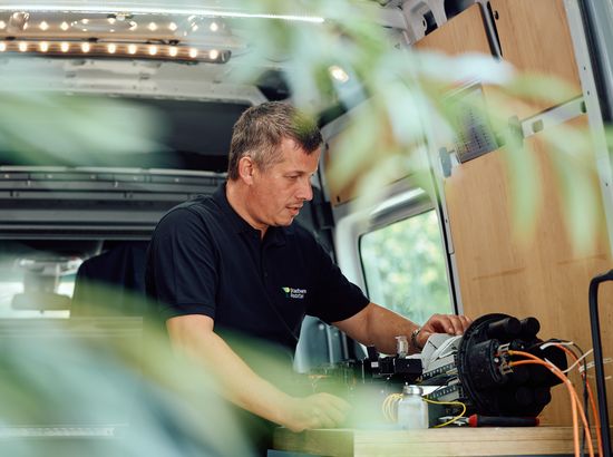 Ein Techniker arbeitet an der Bedienkonsole eines Fahrzeugs oder Geräts und bedient verschiedene Steuerungselemente.