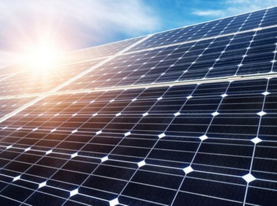 Solarpanelanlage mit mehreren nebeneinander liegenden Photovoltaikmodulen unter Sonnenlicht.