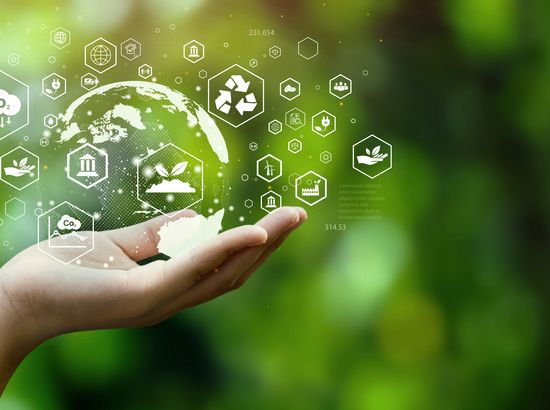 Eine Hand hält eine transparente Erde mit verschiedenen Symbolen für Nachhaltigkeit und Umweltschutz, die auf ökologische Verantwortung und globale Umweltinitiativen hinweist.