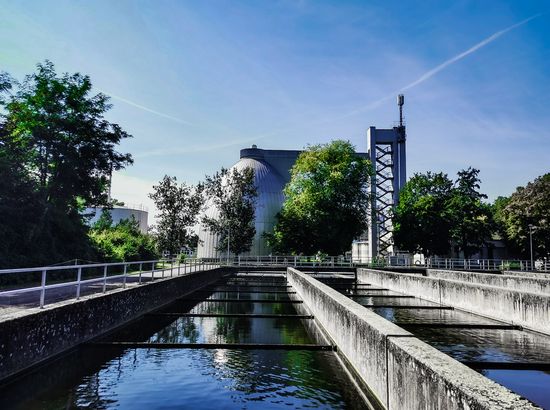 Wasserbehandlungsanlage mit mehreren Klärbecken und technischer Infrastruktur im Hintergrund.